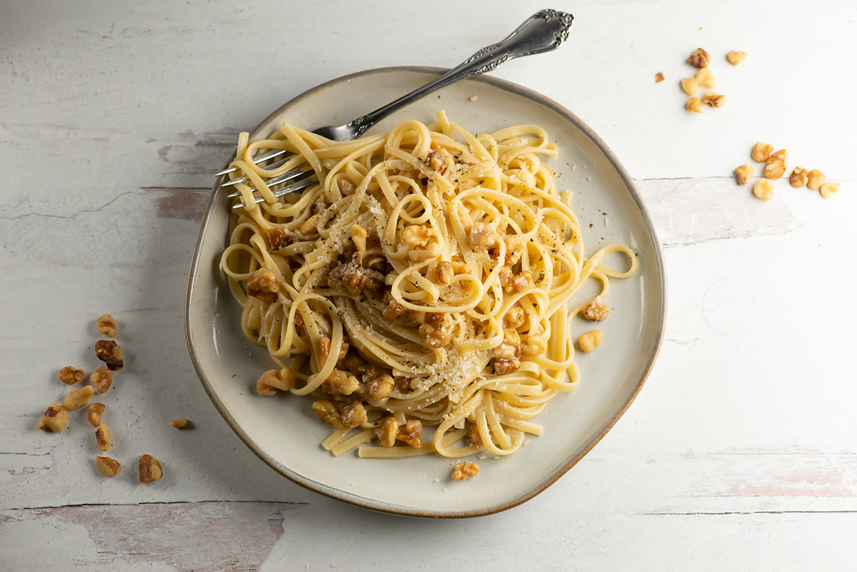 Brown butter walnut pasta on a plate with a fork.