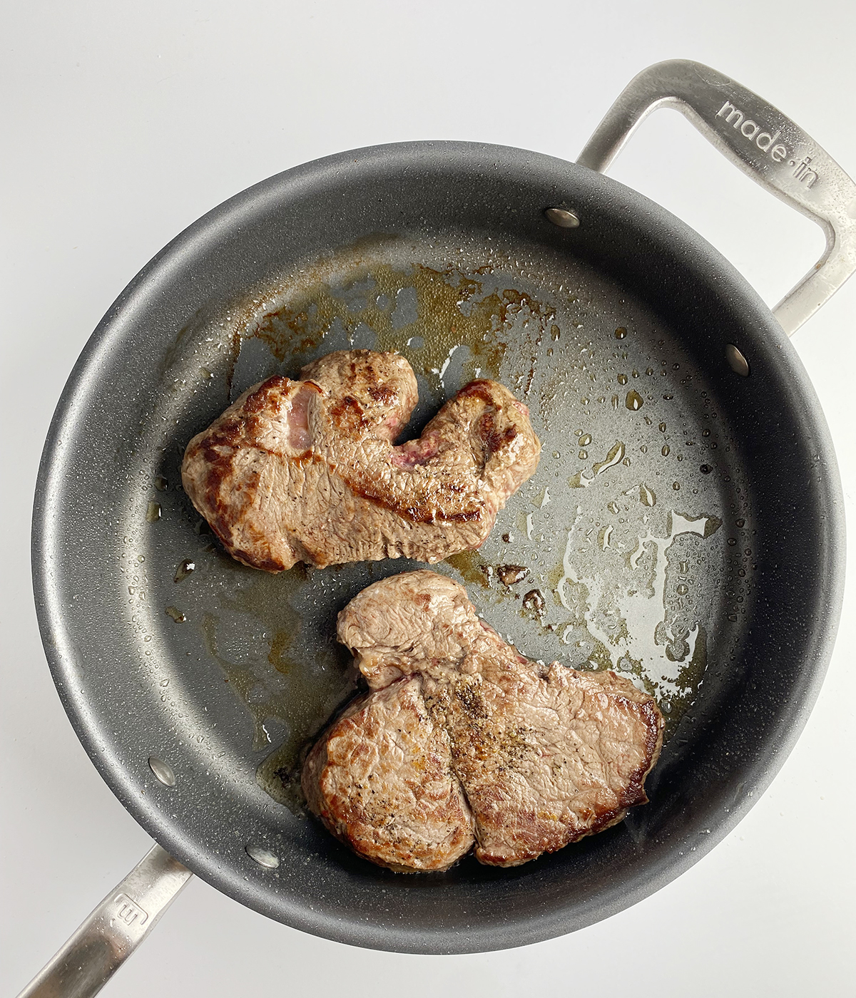 Filet Mignon steaks searing in a skillet.