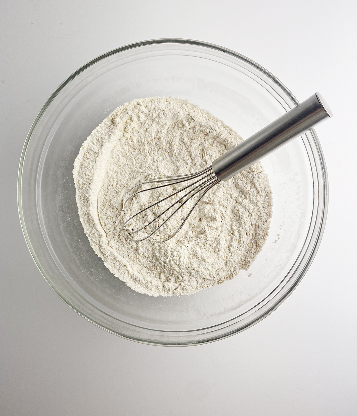 Flour mixture in a mixing bowl with a whisk.