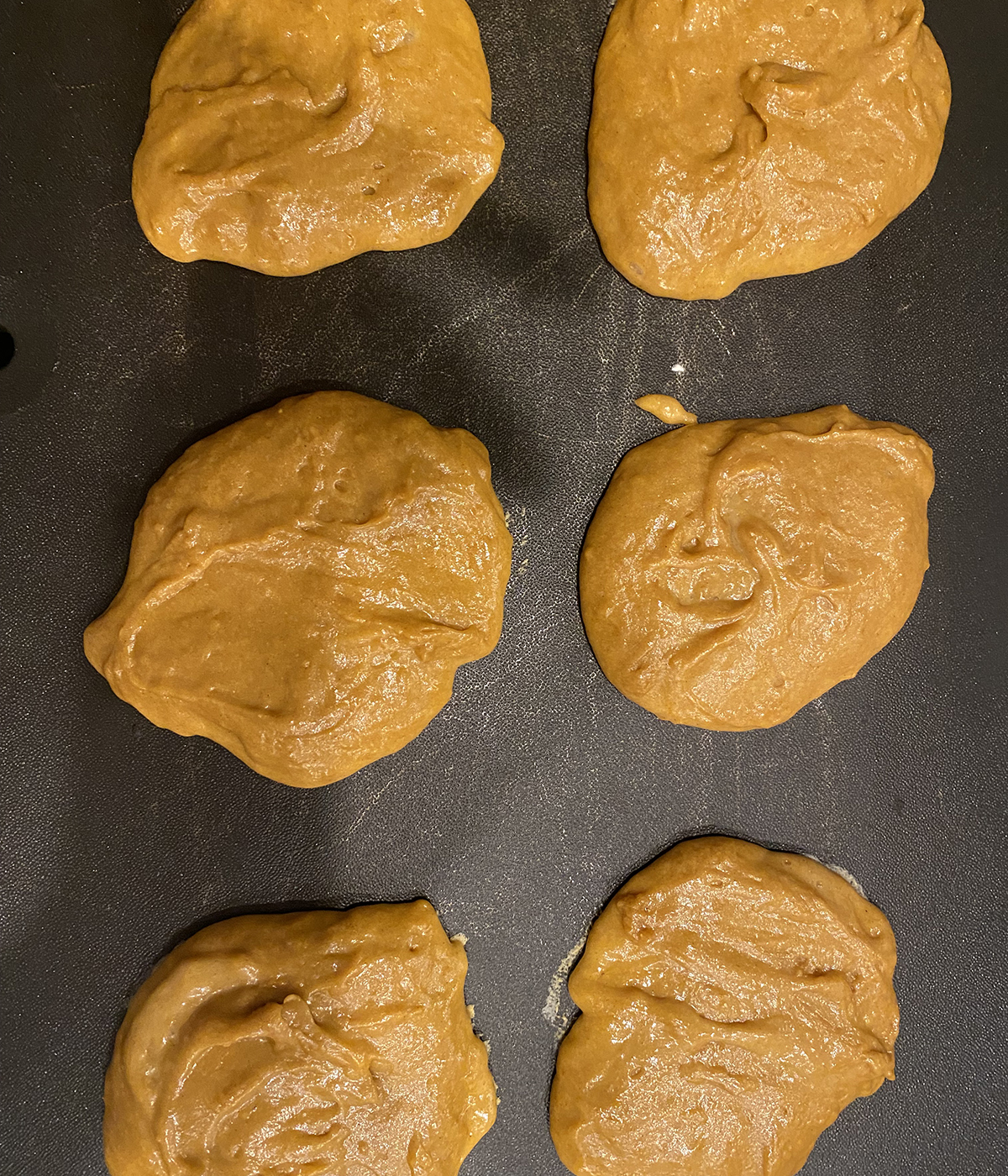 Gingerbread pancakes cooking on a griddle.