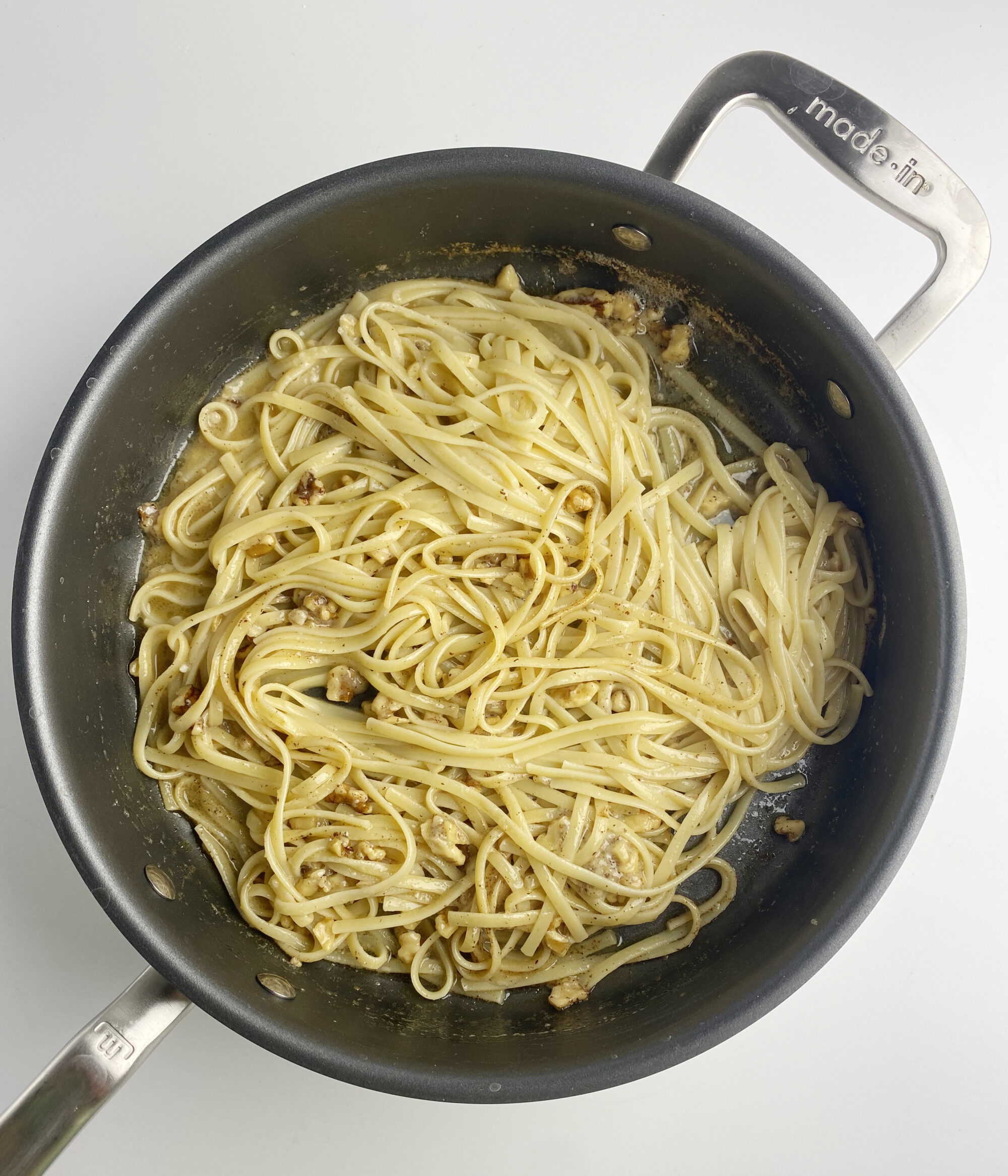 Pasta with brown butter walnut sauce in a skillet.