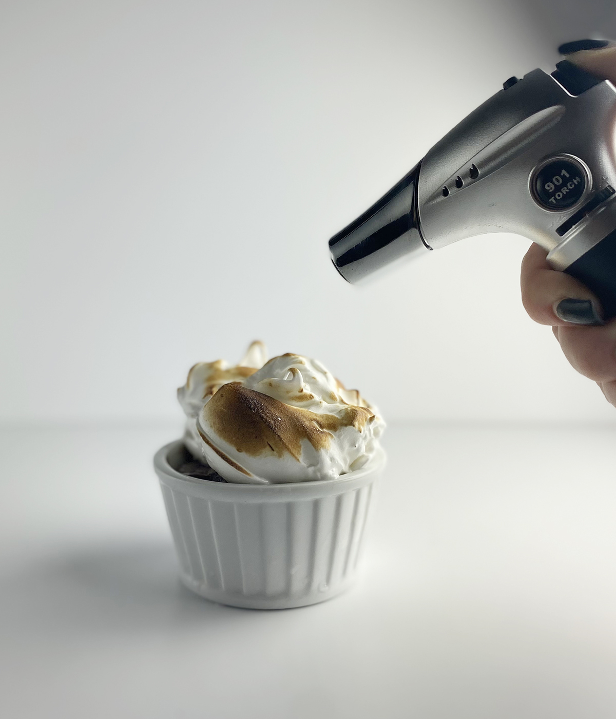 Toasting a mini Baked Alaska with a blow torch.