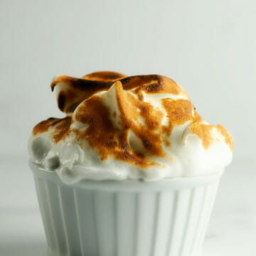 Individual baked alaska in a white dish.