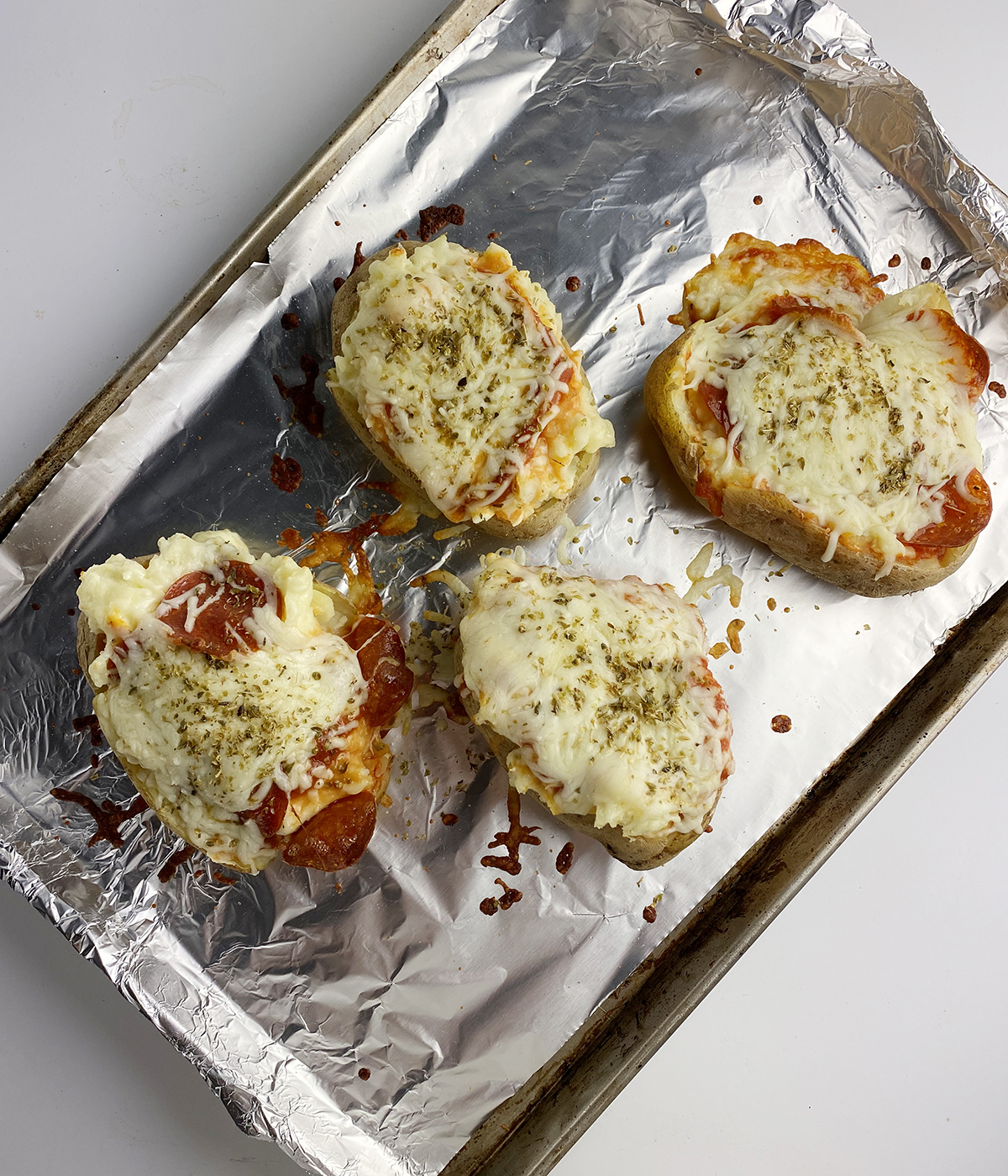 Baked pizza potatoes on a baking tray.