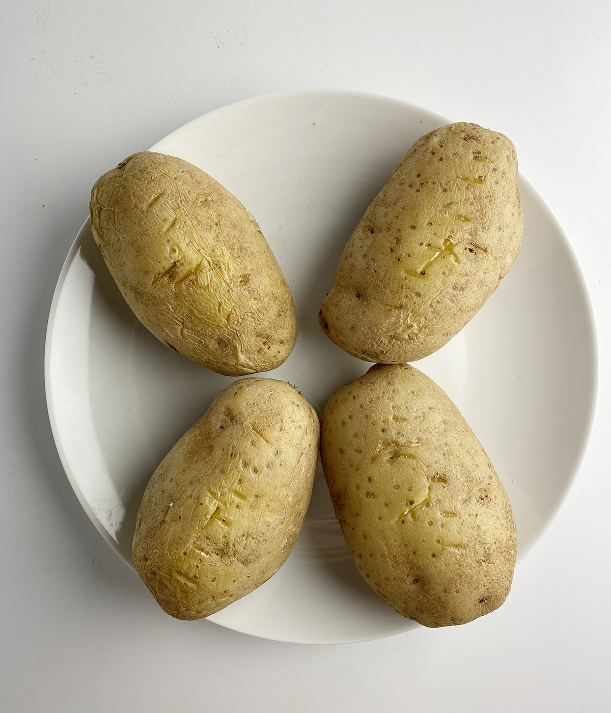 Cooked russet potatoes on a plate.
