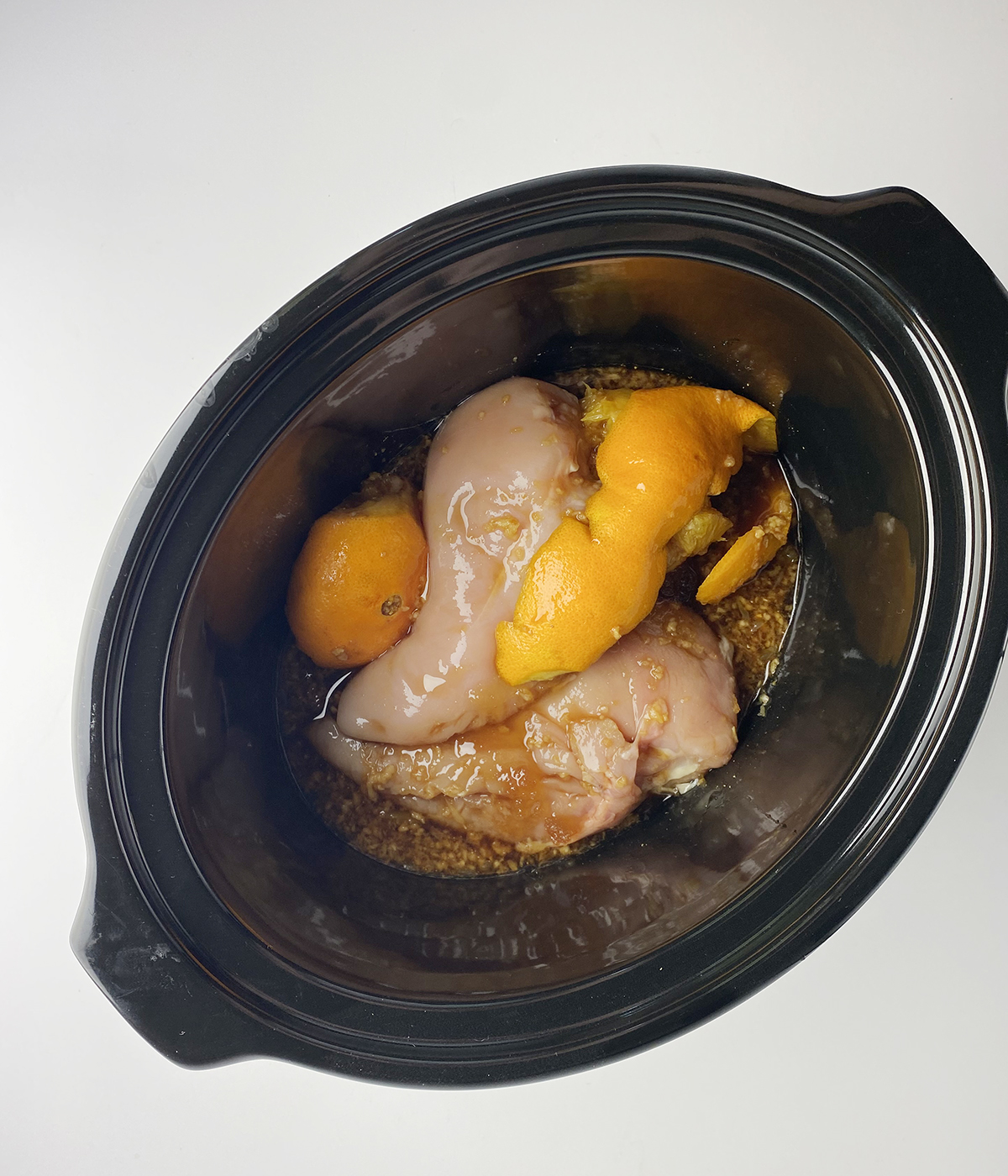Sticky chicken ingredients in a slow cooker ready to be cooked.