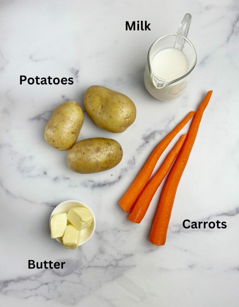 Ingredients for carrot mashed potatoes on a marble counter.