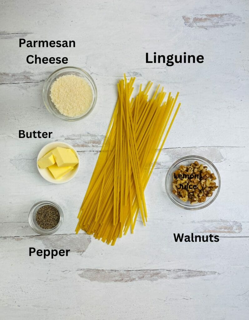 Ingredients for walnut pasta on a wooden counter.