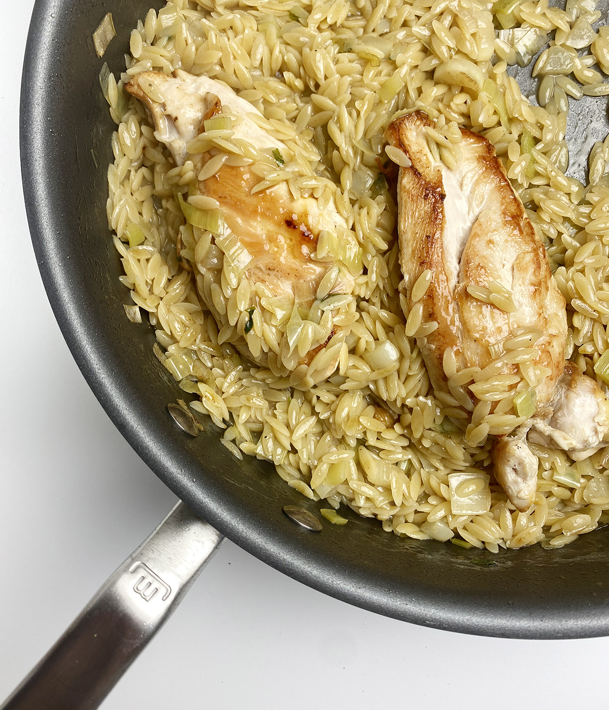 Lemon chicken with orzo in a skillet