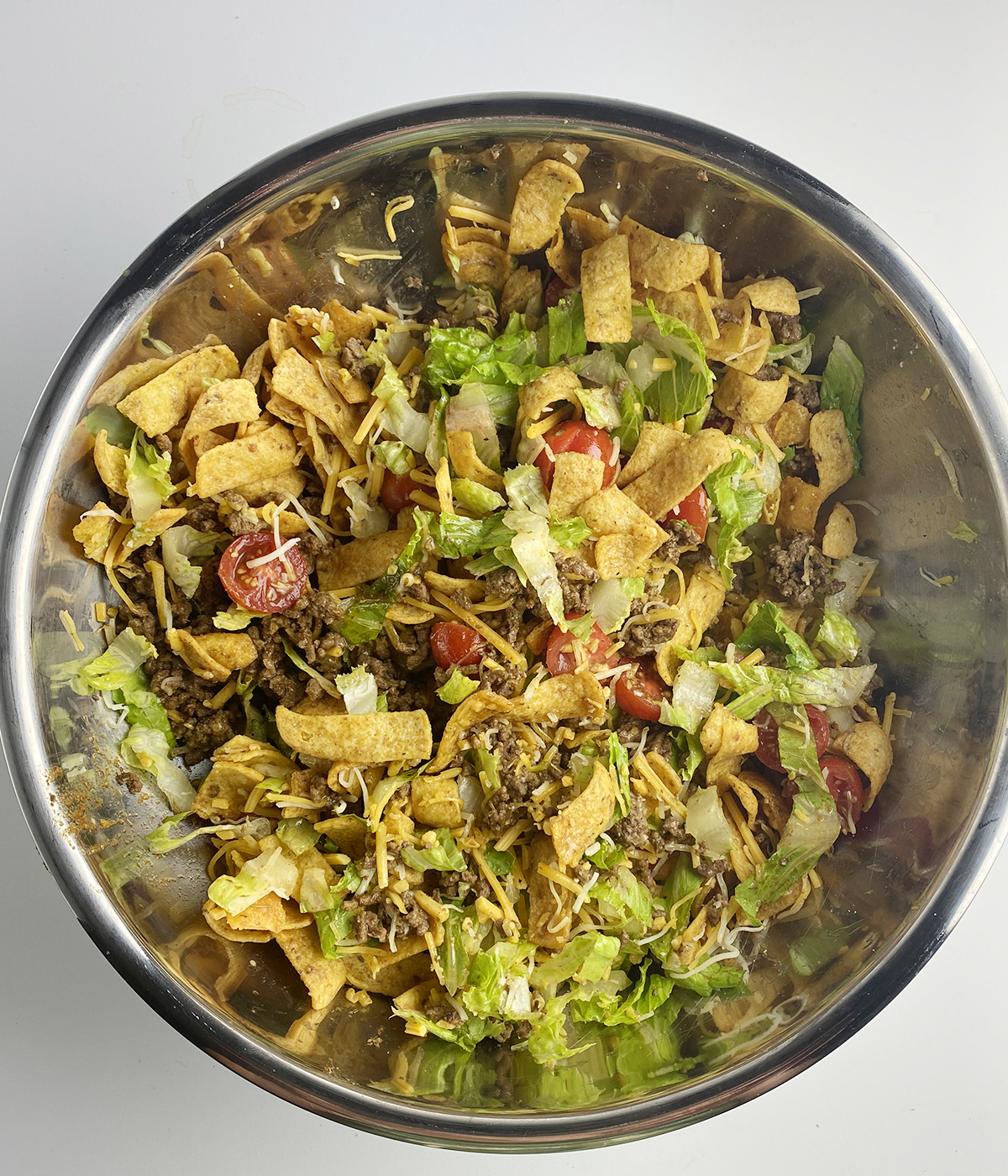 Mixed together corn chip taco salad in a bowl.