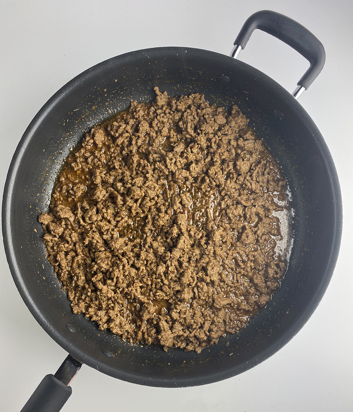 Cooked ground beef with taco spices in pan.