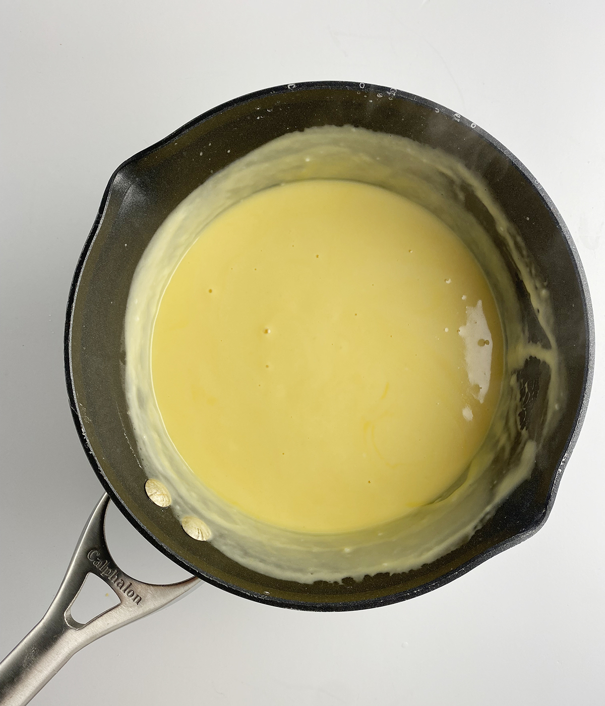 Creamy Velveeta cheese sauce on a saucepan.