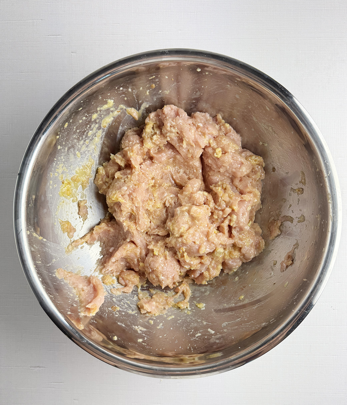 Chicken meatballs mixture in a mixing bowl.