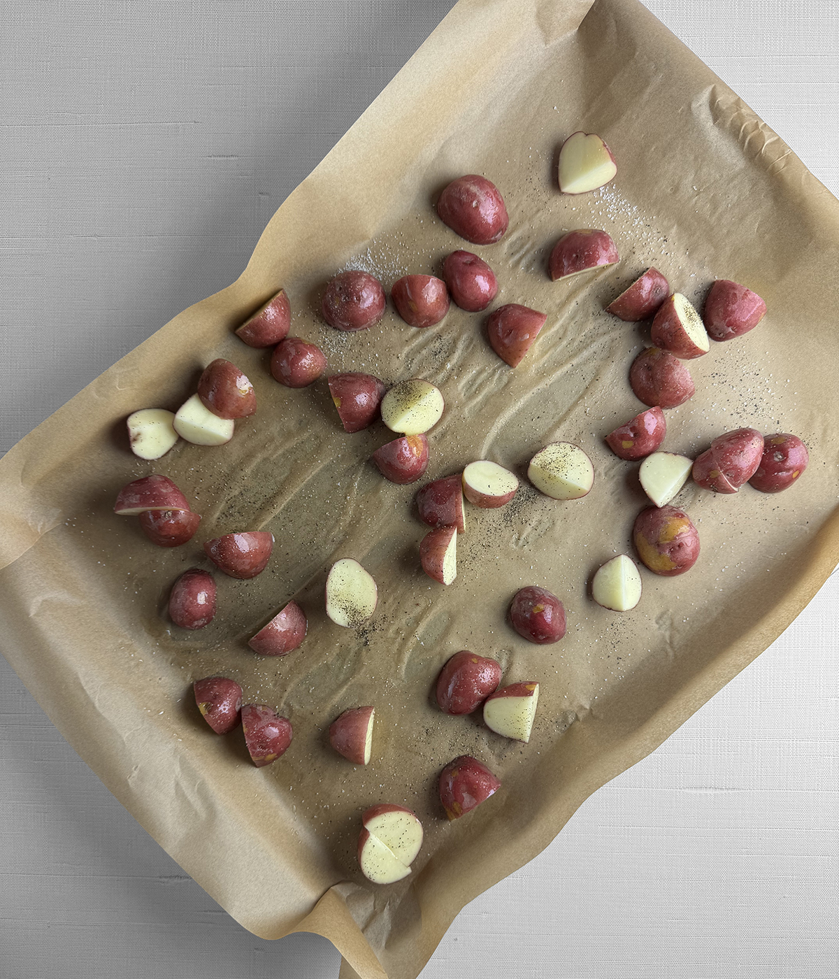 Baby potatoes on a baking sheet ready for the oven.