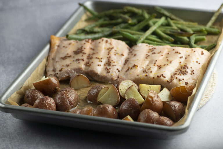 Roasted salmon and vegetables on a baking pan.