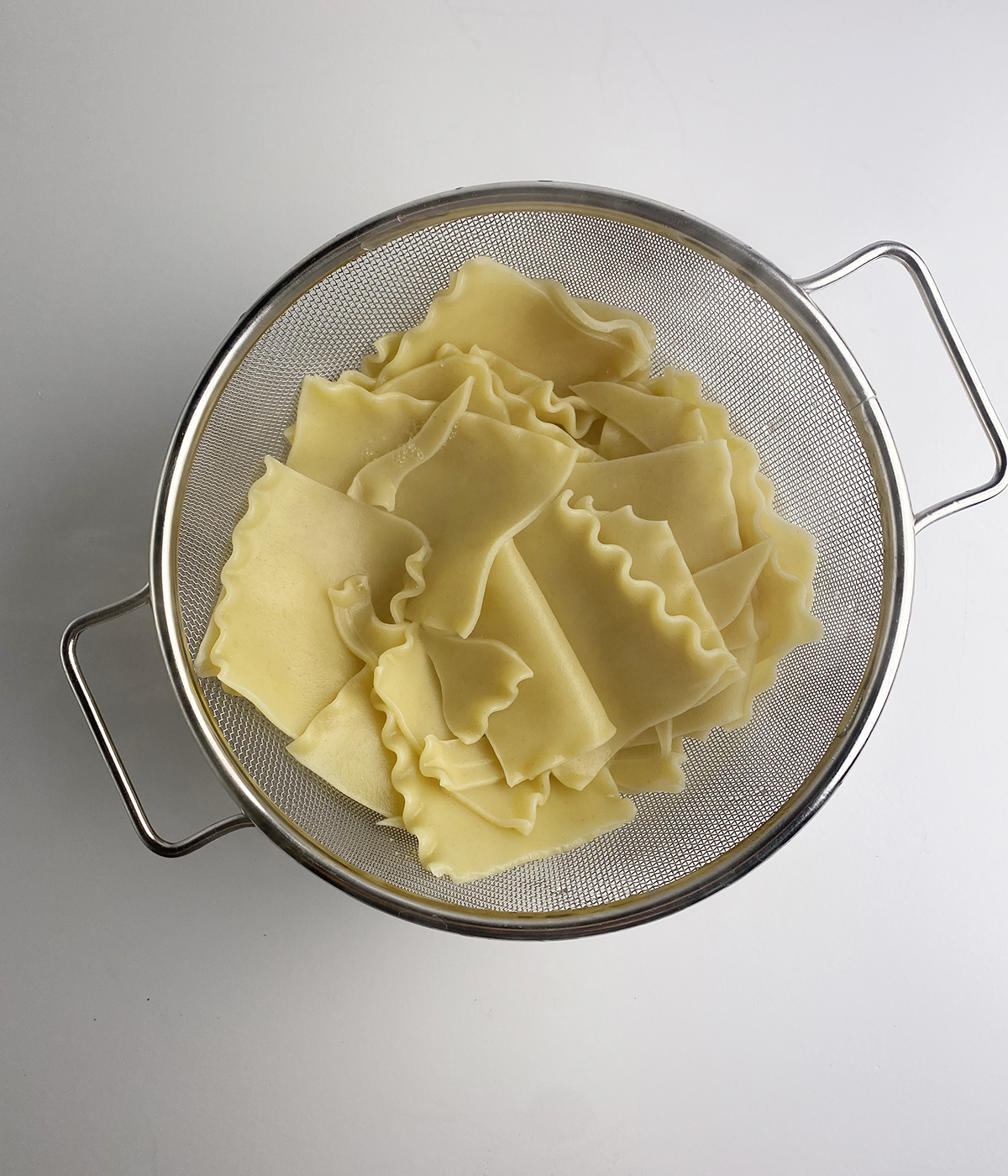 Lasagna noodles draining in a strainer.