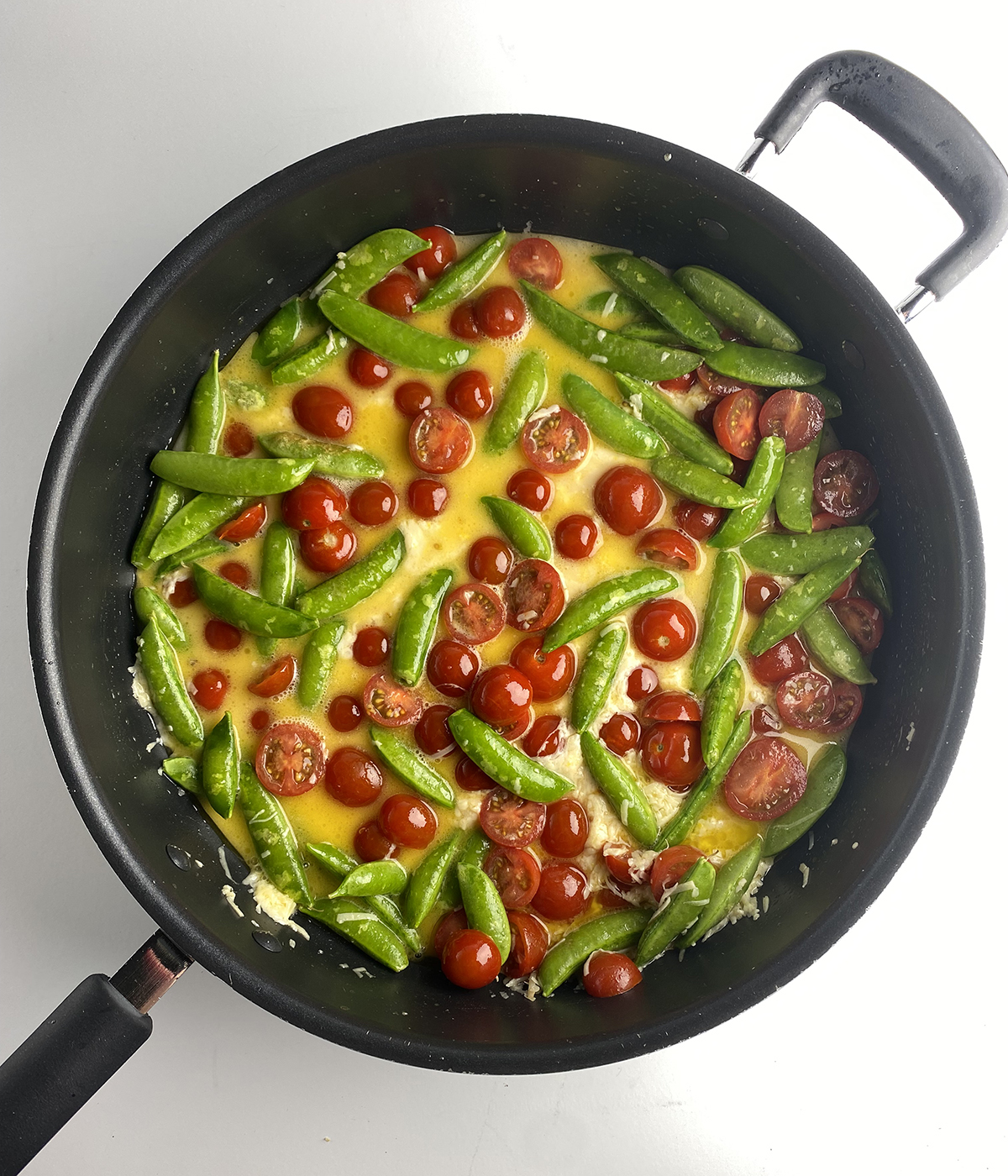 Vegetables in a butter sauce in a skillet.