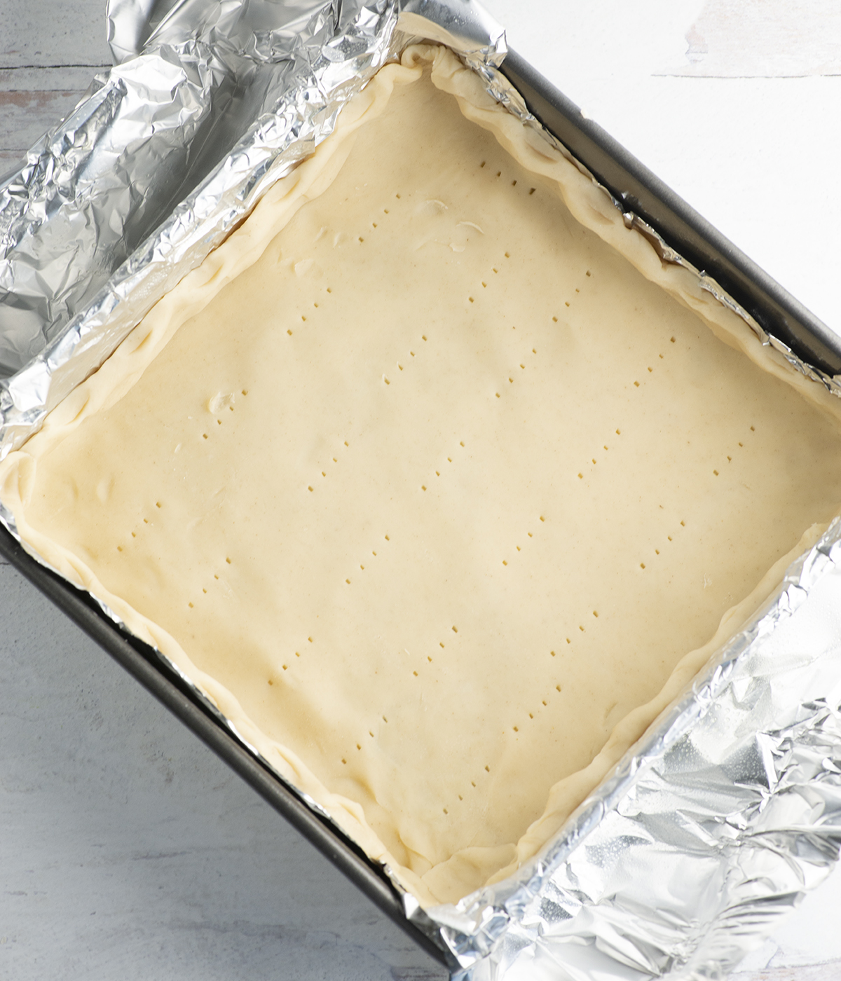 Piecrust pressed into a foil lined pan.