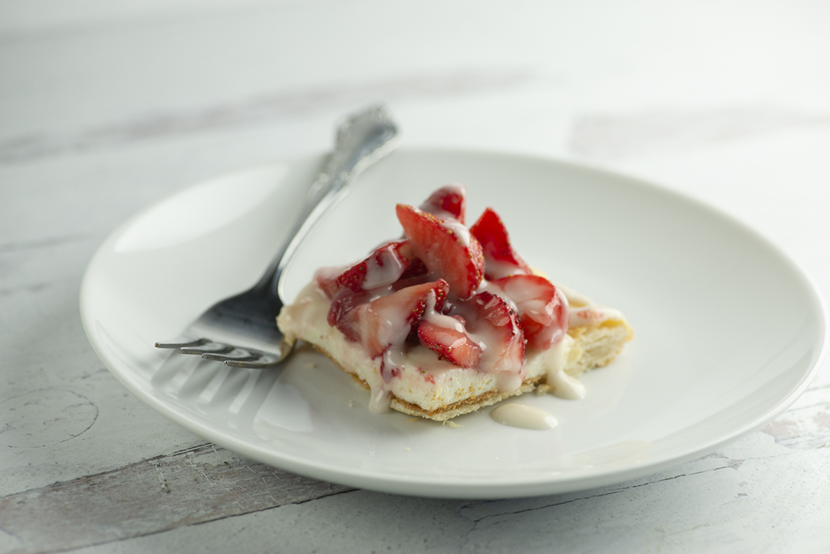 Strawberry slab pie on a plate with a fork.