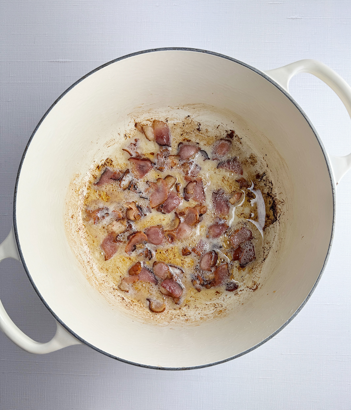 Bacon cooking in a pot.