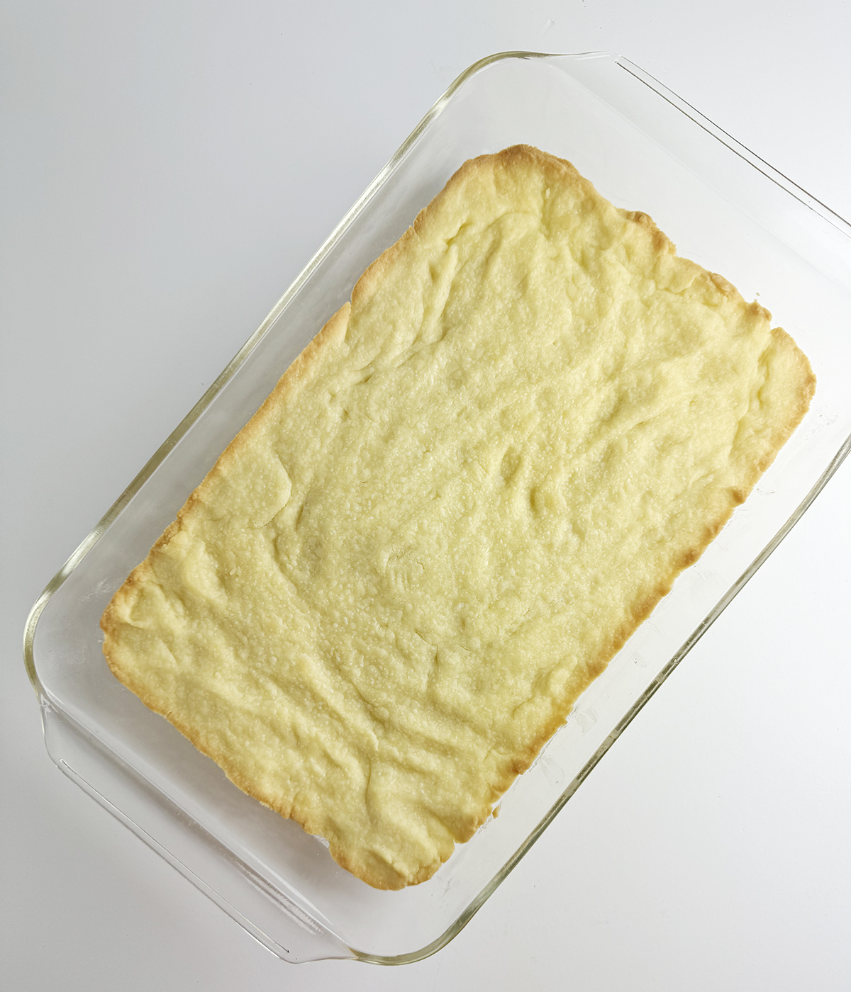 Baked shortbread layer of blueberry cheesecake squares.