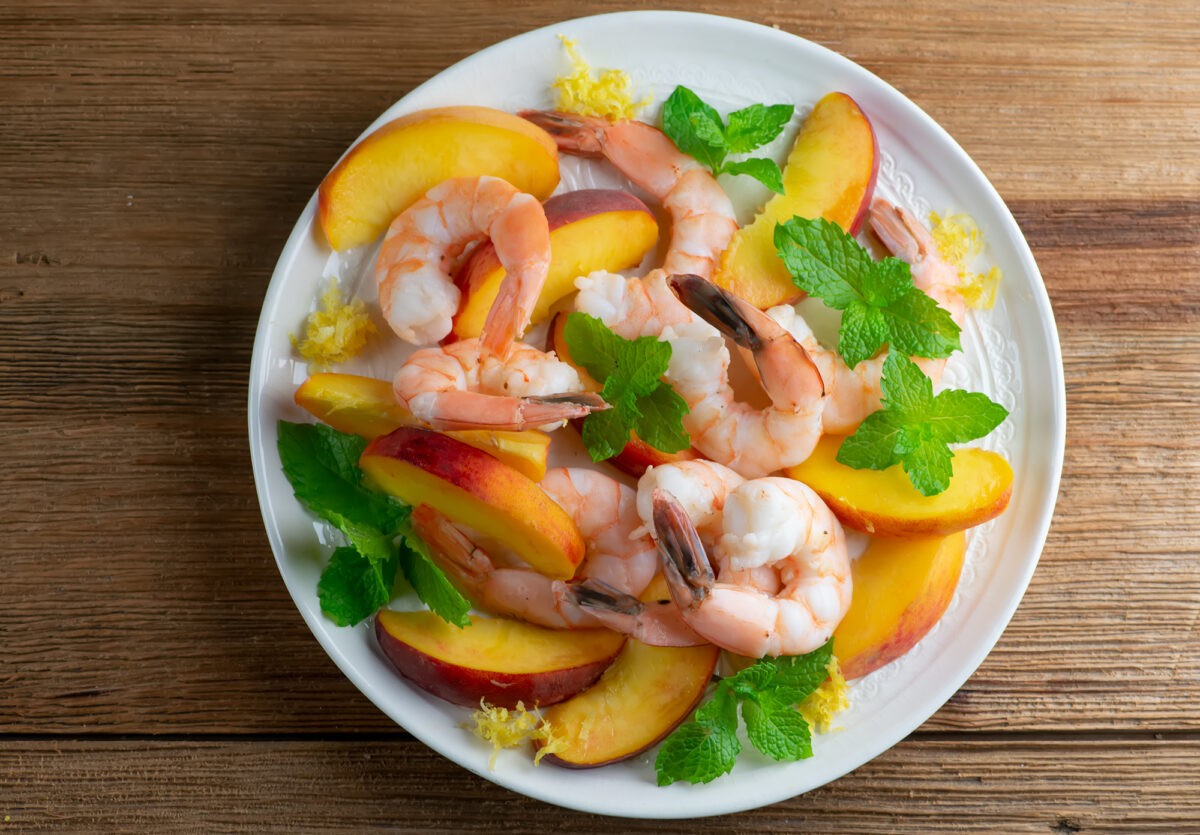 Cool shrimp and peach salad on a plate.