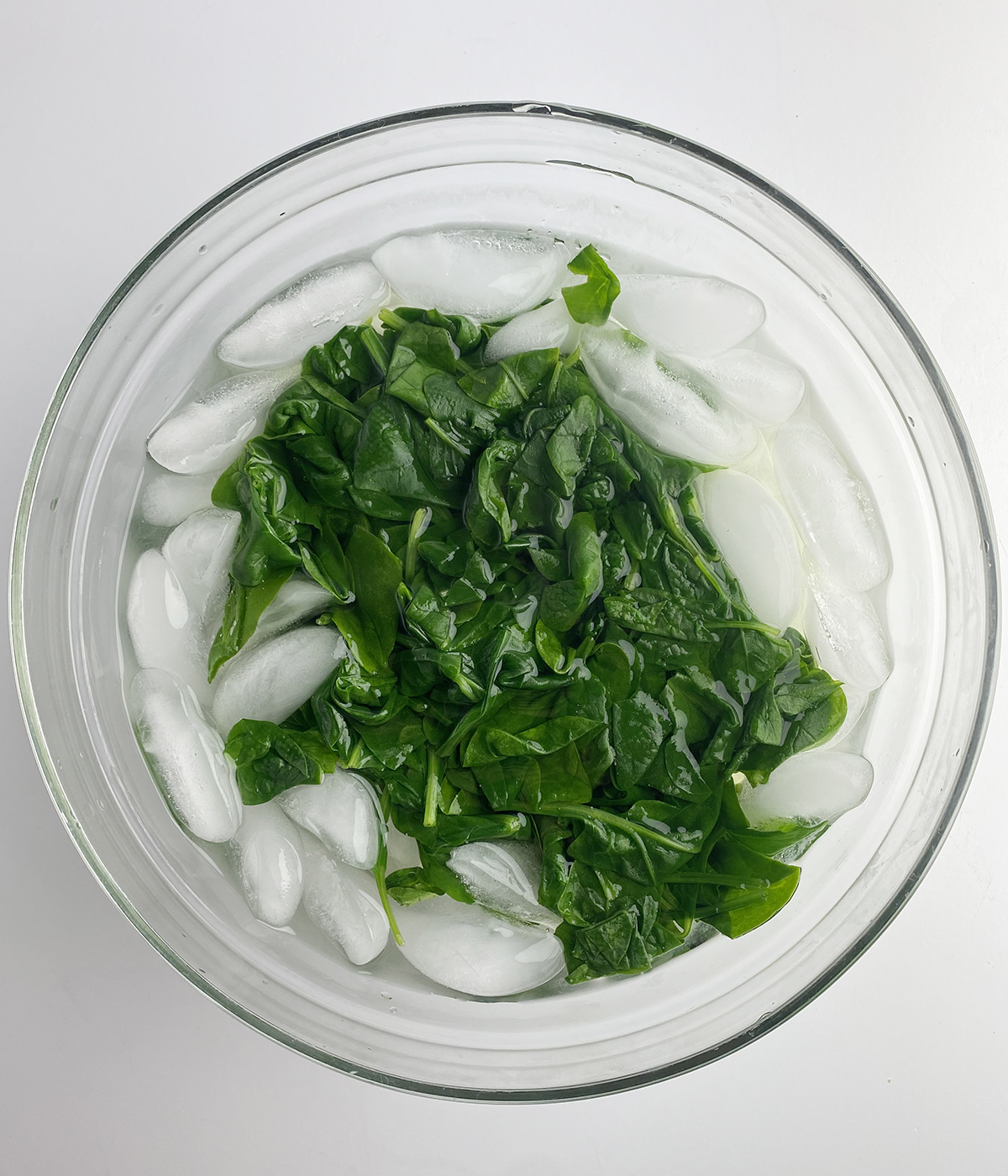 Cooked spinach in an ice bath.