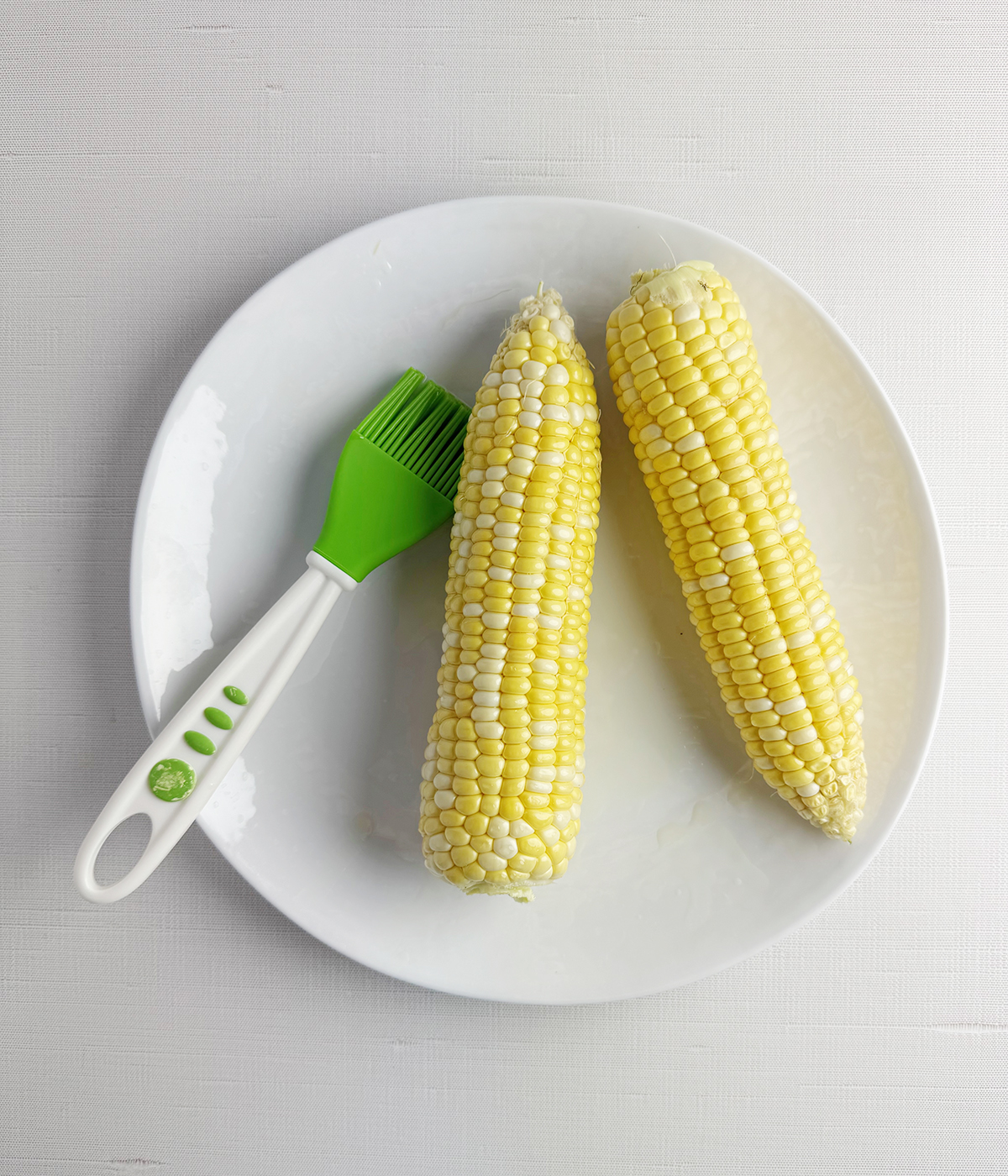 Oil brushed corn with a basting brush.