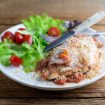 One Pan Chicken Parmesan on a plate with fork and knife.