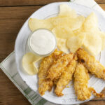 Potato chip chicken tenders on a plate.