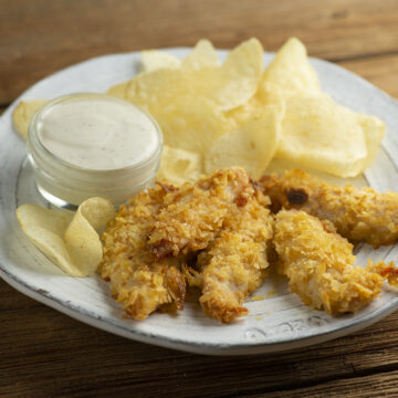 Potato chip chicken tenders on a plate.