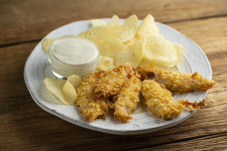 Potato chip chicken tenders on a plate.