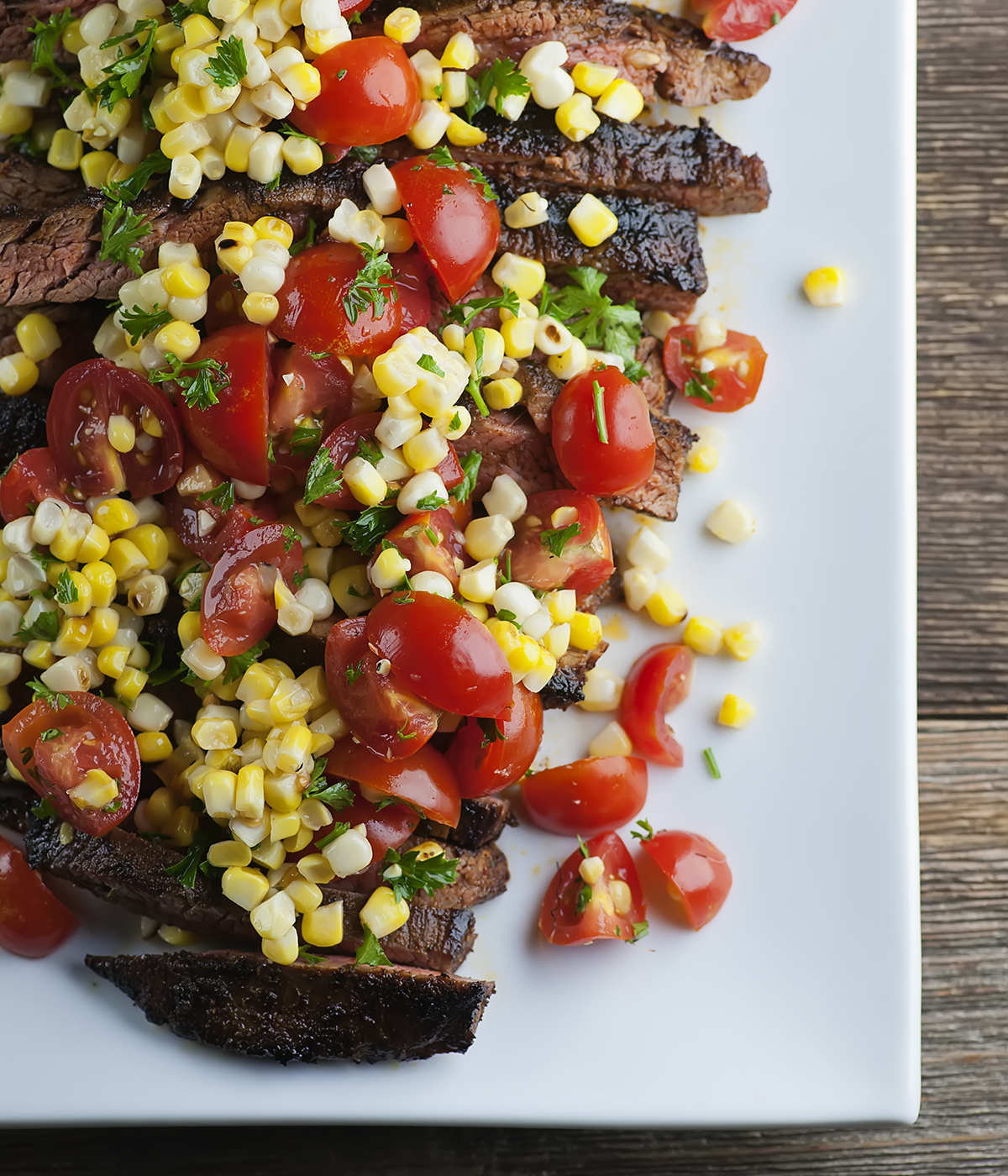 Spice Rubbed Steak with Corn Tomato Salsa on a platter.