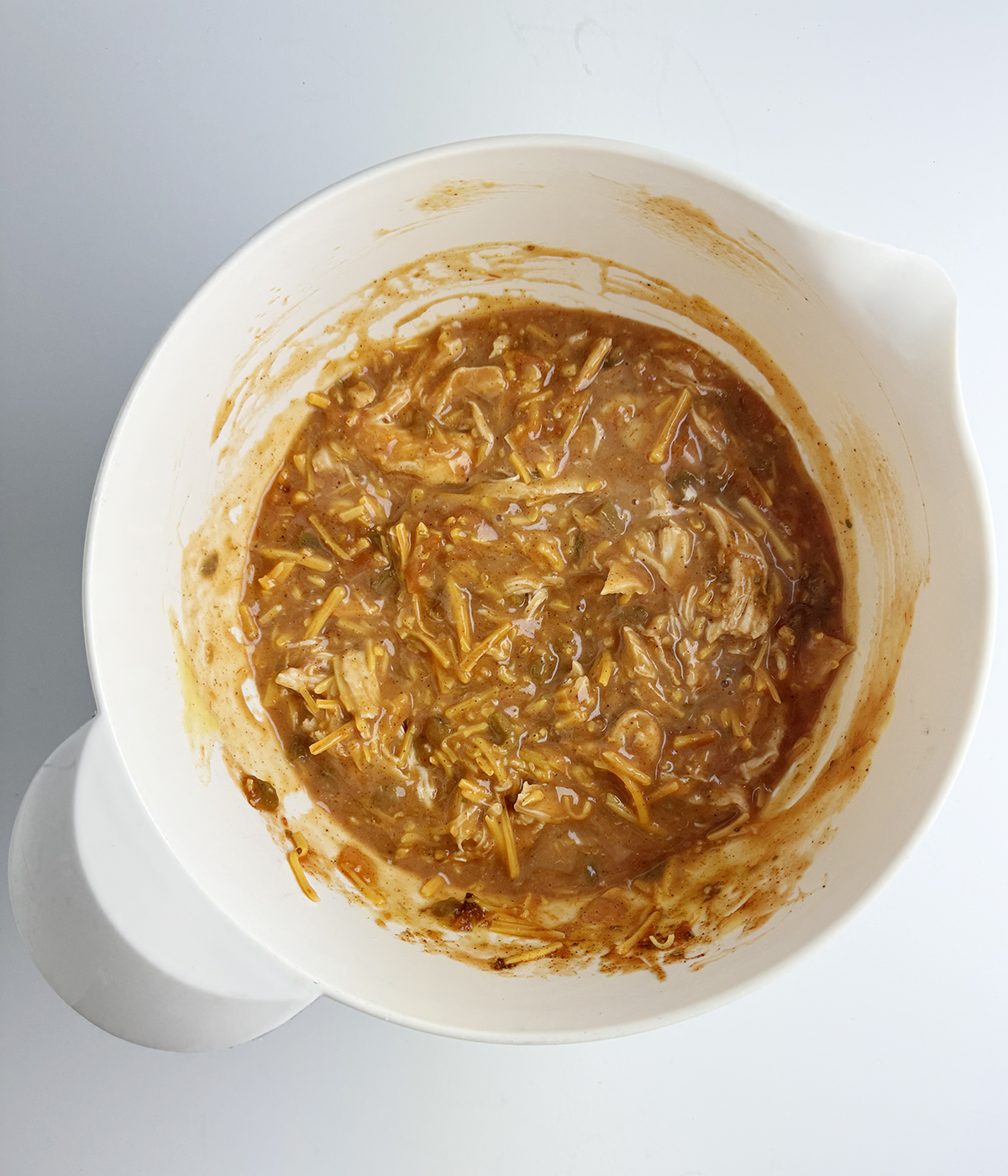 Chicken and tomato mixture in a mixing bowl.