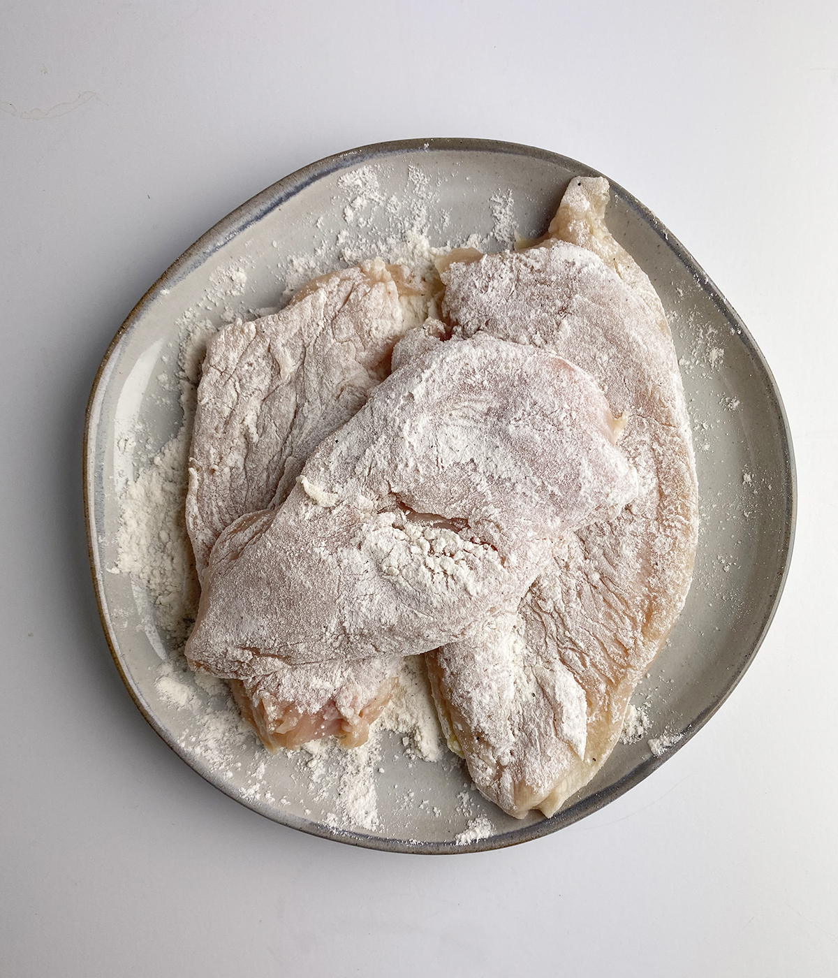 Chicken breasts dredged in flour.