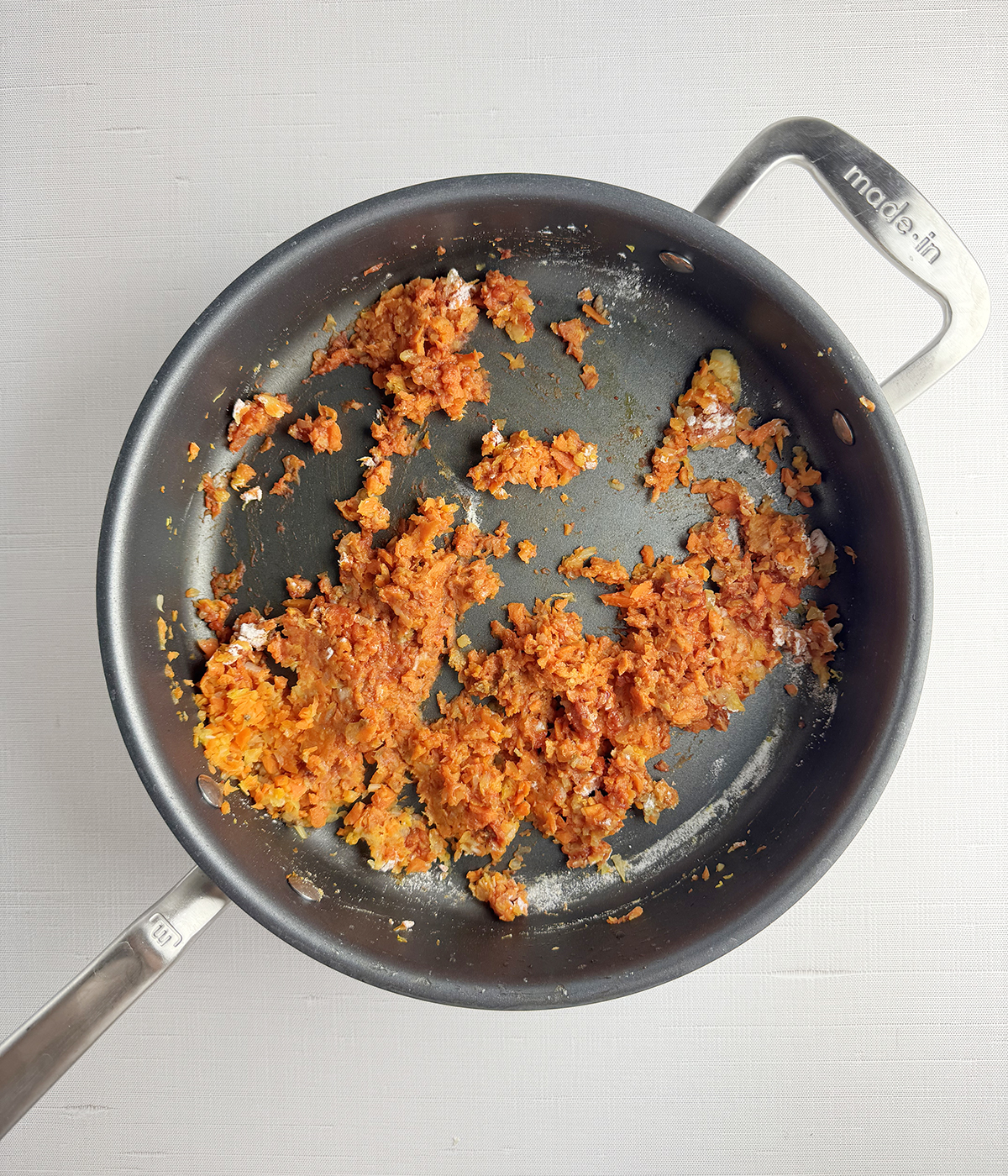 Chopped carrots cooking in a skillet.