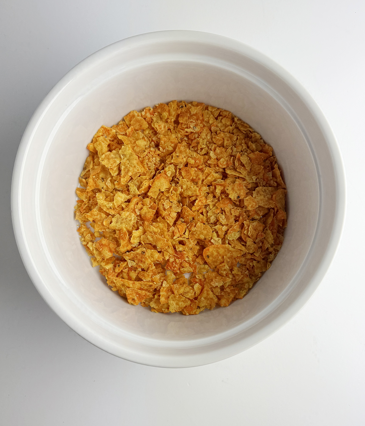 Crushed Doritos in a casserole dish.