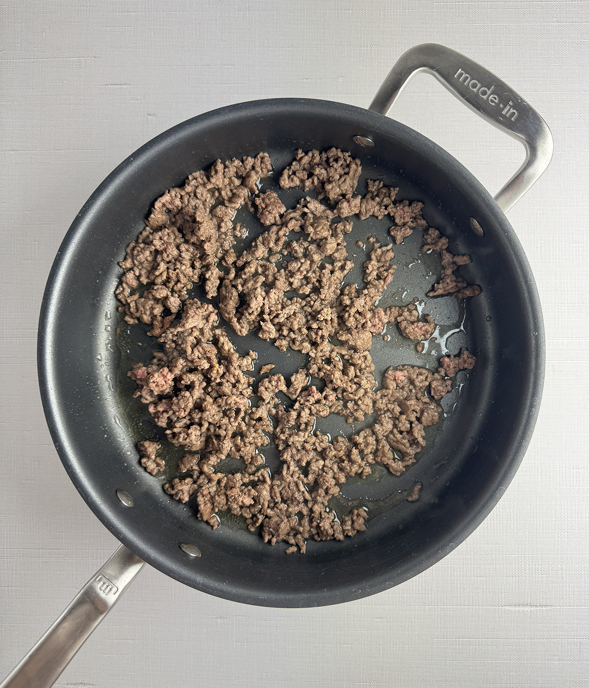 Ground beef cooking in a skillet.