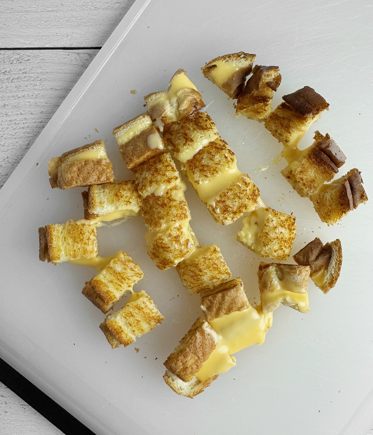 Grilled chese croutons on a cutting board.