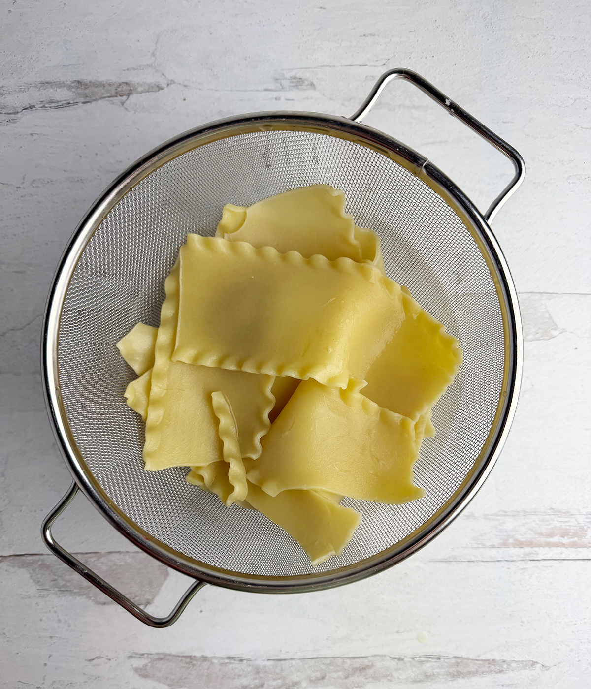 Lasagna noodles draining in a strainer.