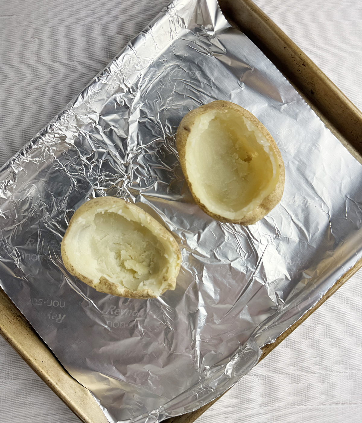 Scooped out potato skins on a baking dish.