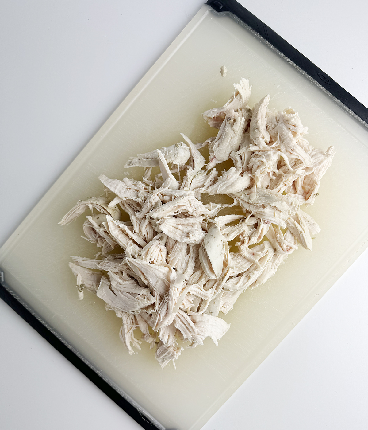 Shredded chicken on a cutting board.