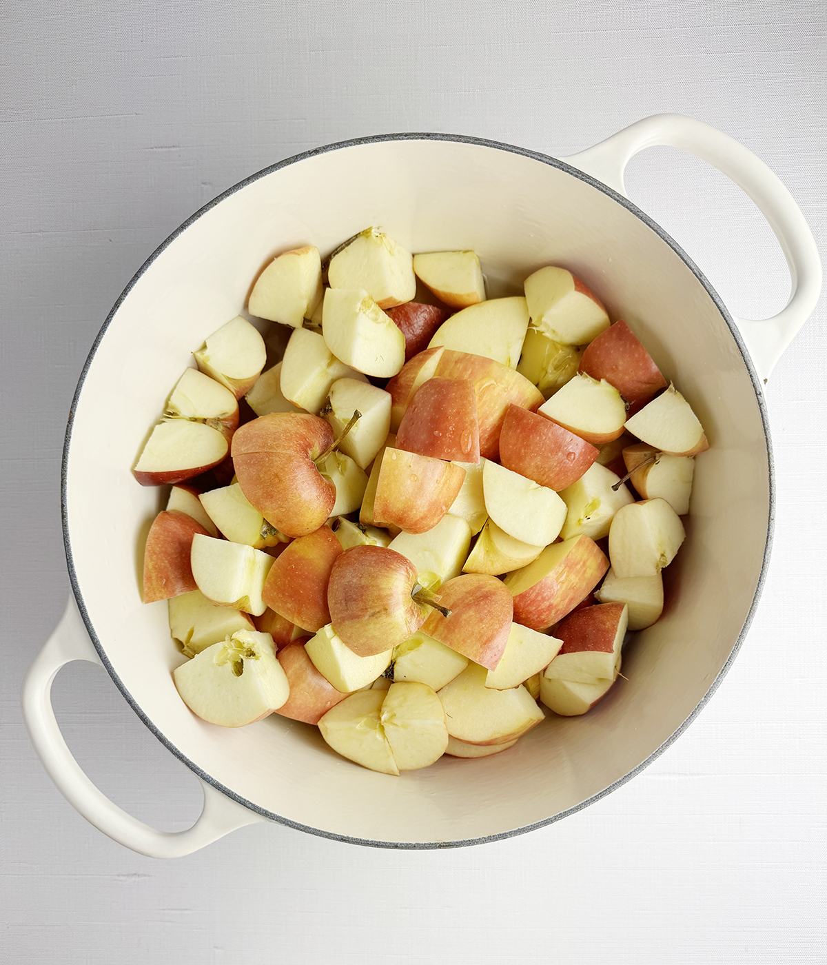 Chopped raw apples in a pot.