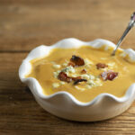 Pumpkin bacon soup in a bowl with a spoon.