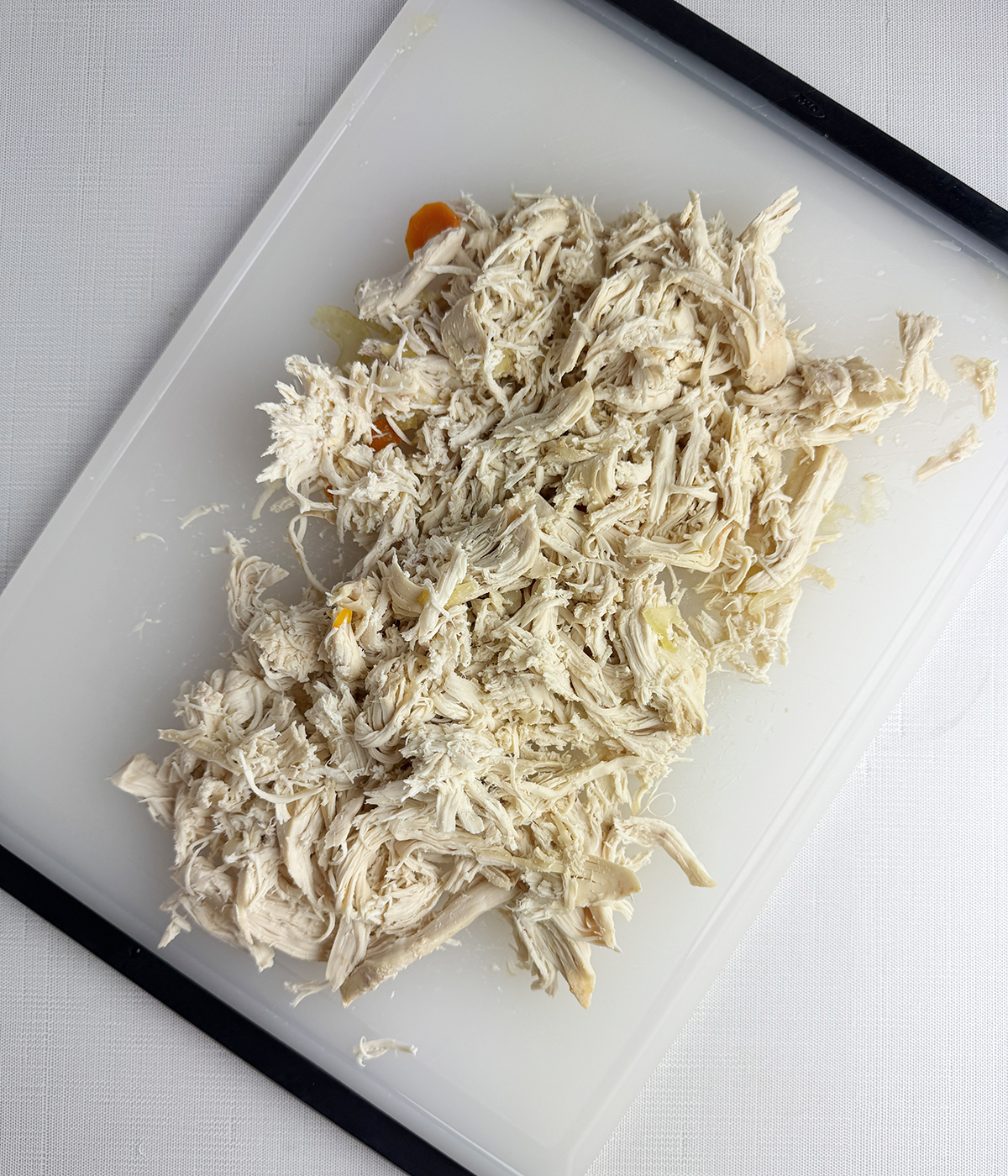 Shredded chicken on a cutting board.