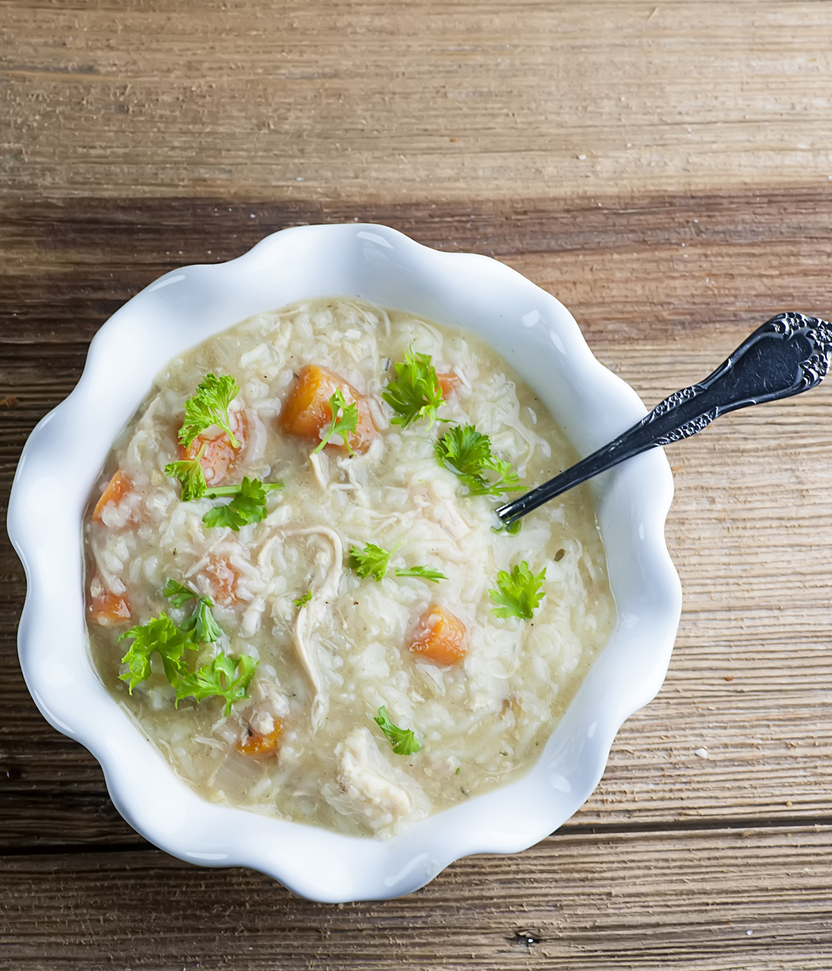 Slow cooker chicken noodle soup in a bowl with a spoon.
