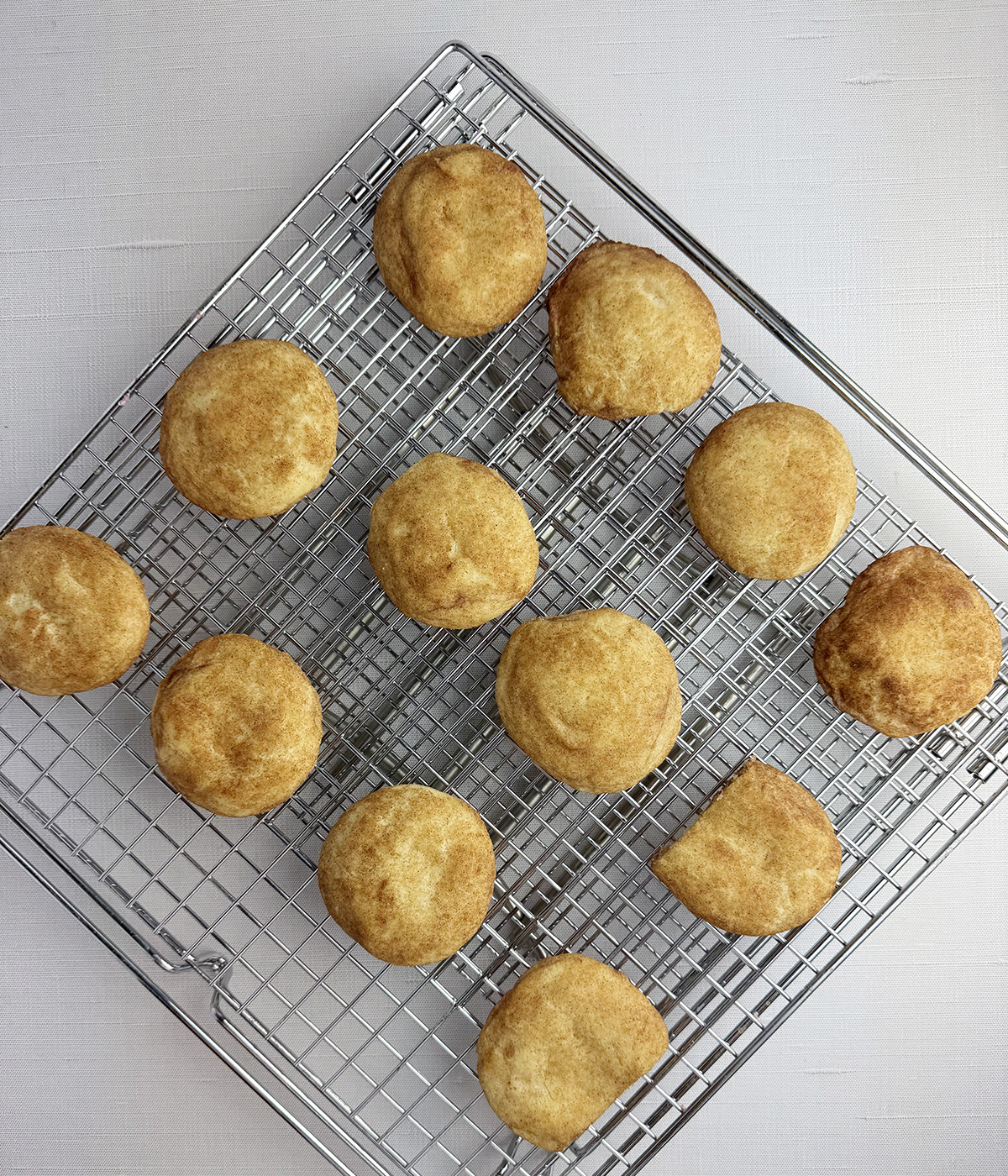 Snickerdoodle cookies cooling on a rack.