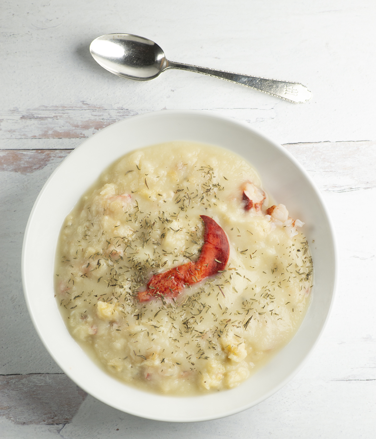 Cauliflower soup in a bowl with a spoon.