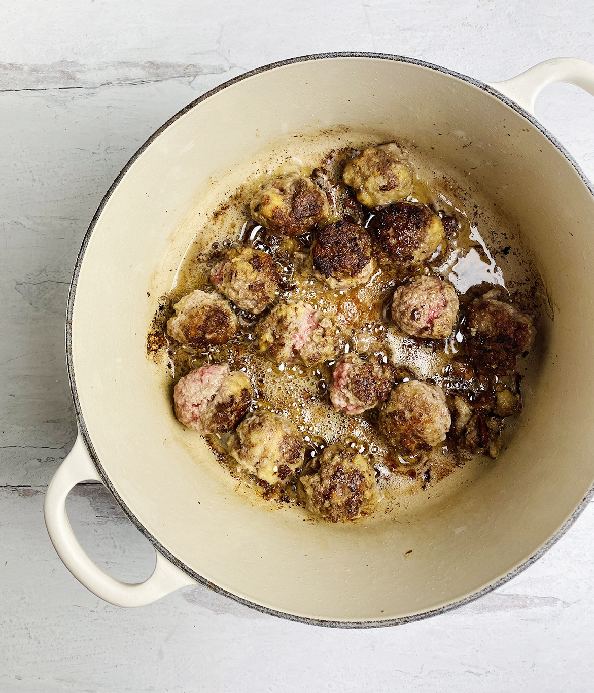 One pot spaghetti and meatballs meatballs searing in a pot.