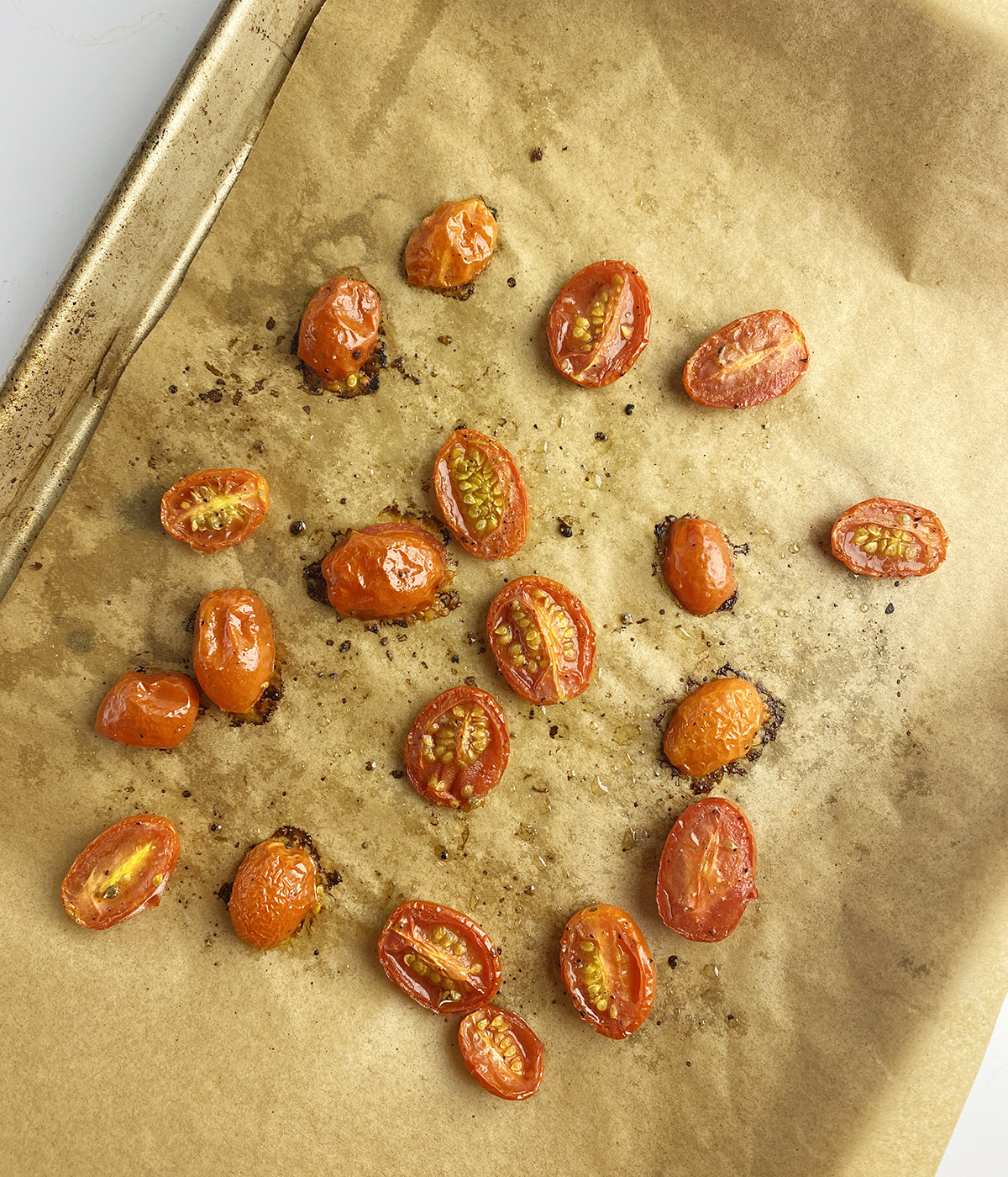 Roasted cherry tomatoes on a baking pan.